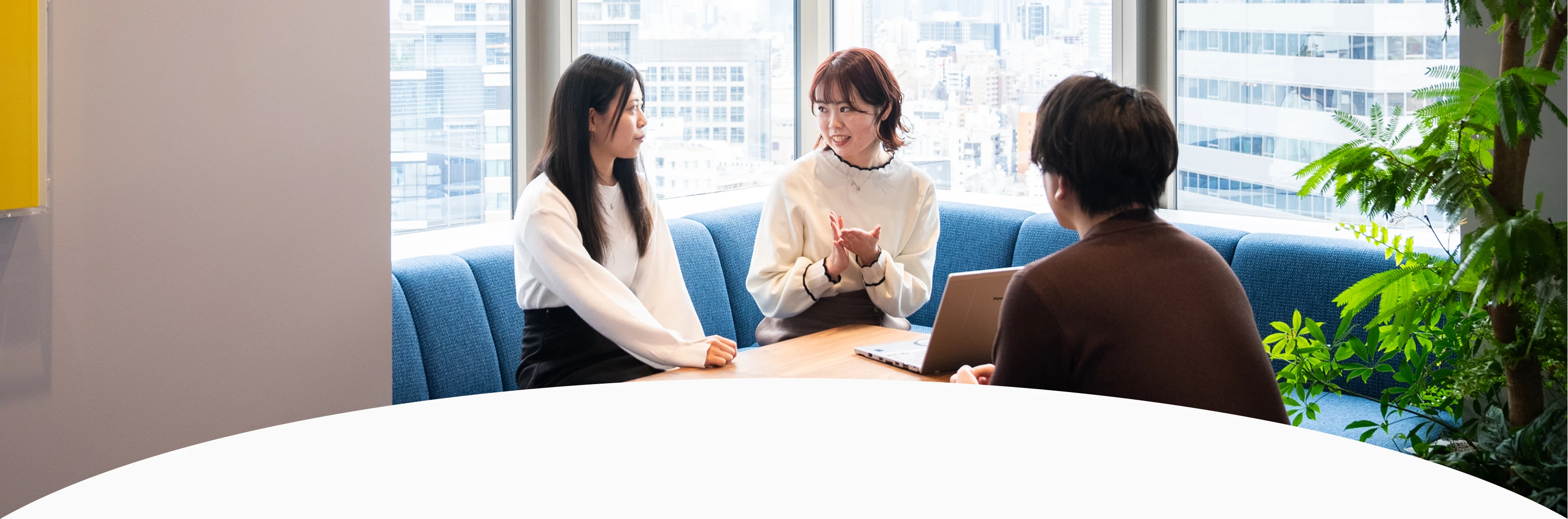 会社のソファで話し合う３人の社員